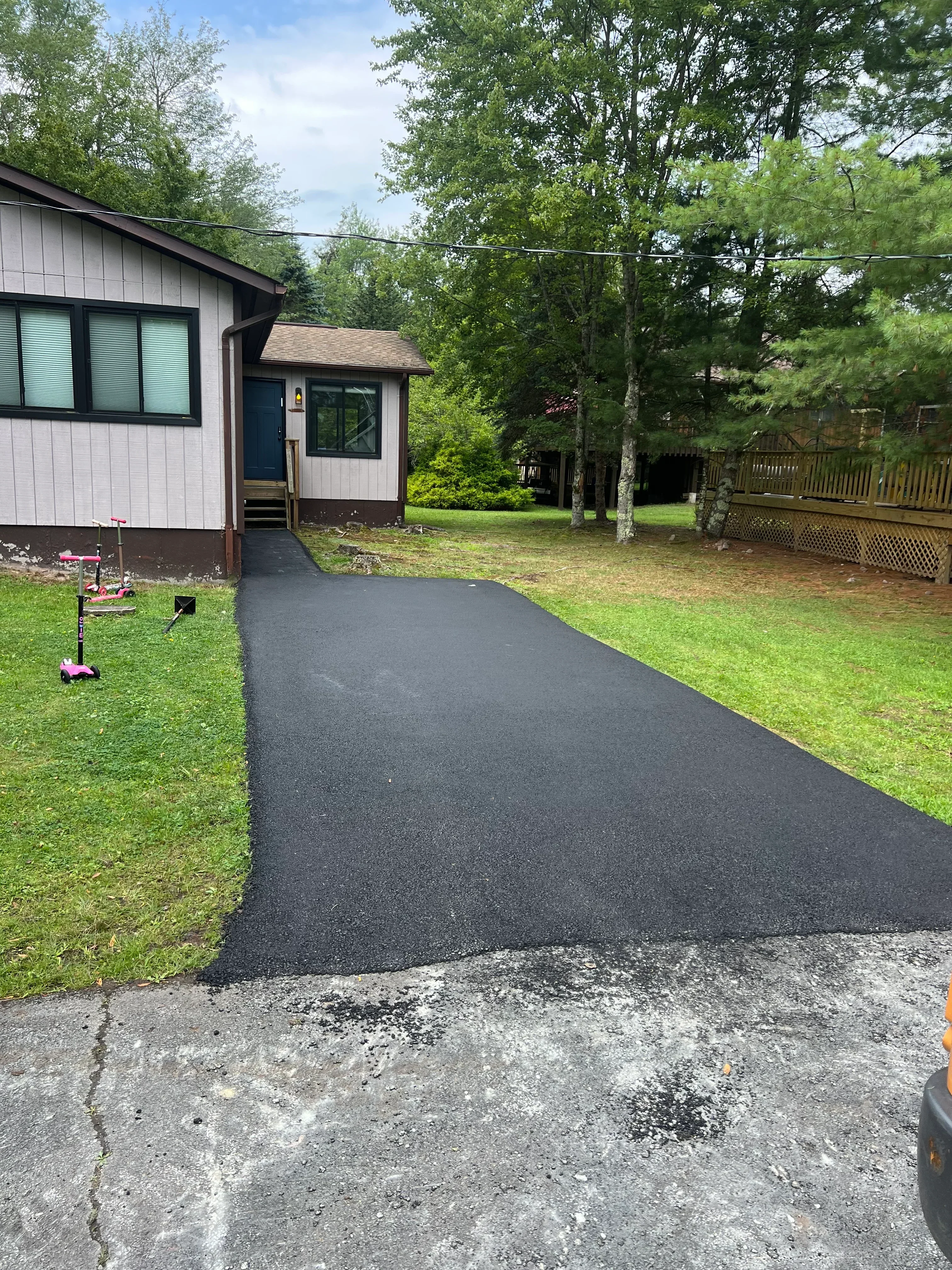 New asphalt driveway with smooth dark surface and clean edges at residential home