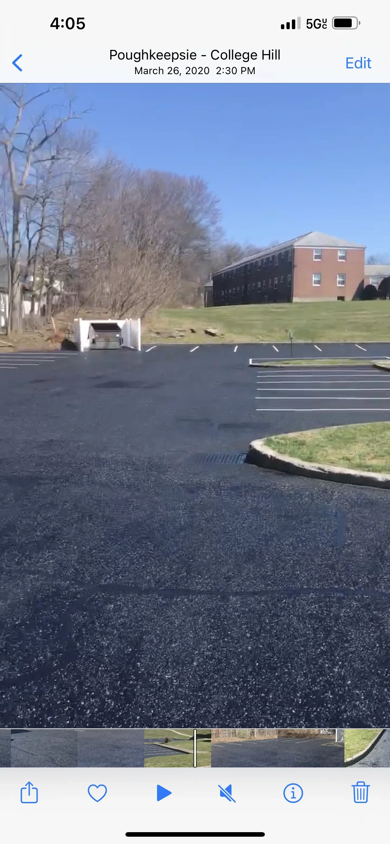 Newly paved asphalt parking lot with white striping and concrete curb edging