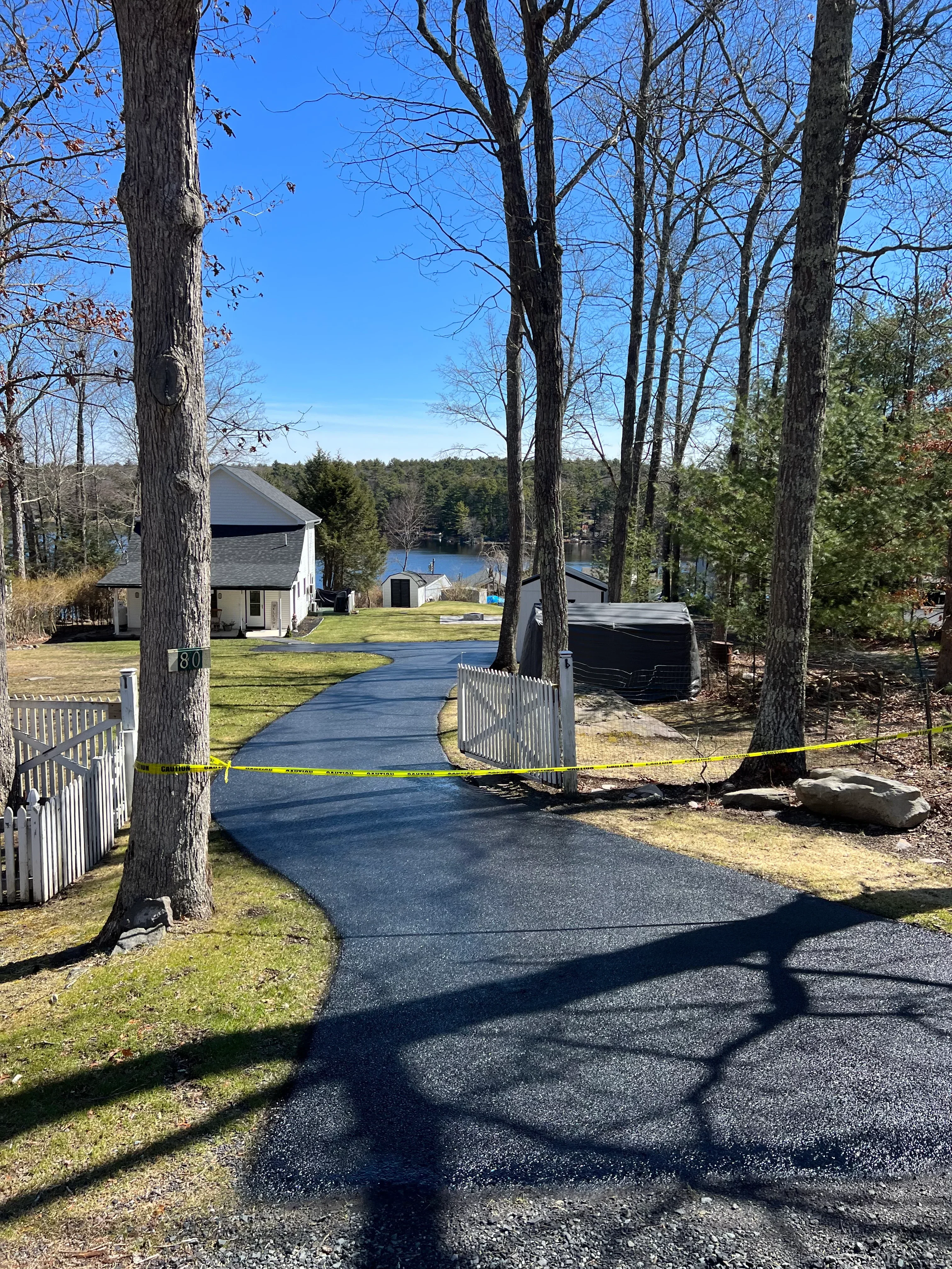 New asphalt driveway with dark finish and clean edges at residential property