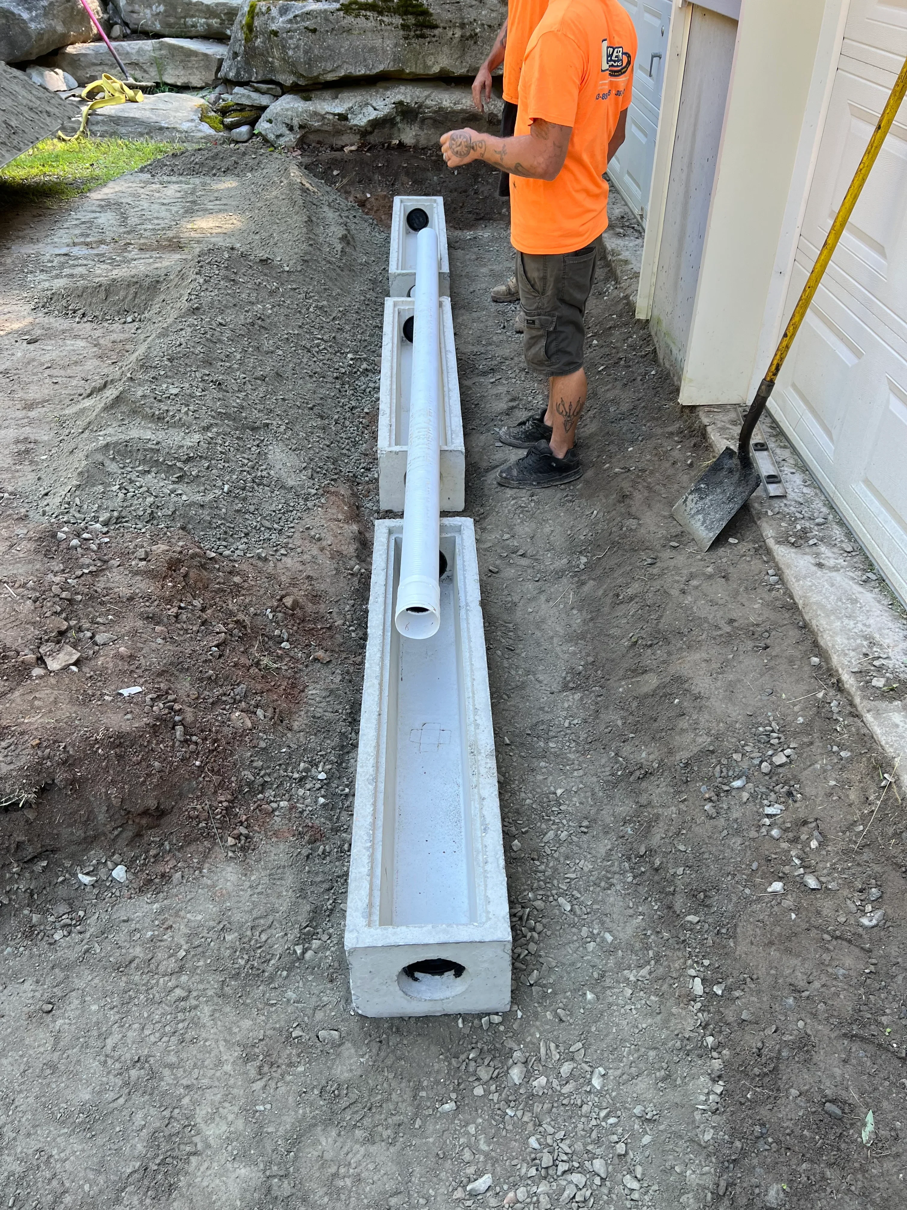 White PVC drainage system with outlet ports installed in concrete foundation