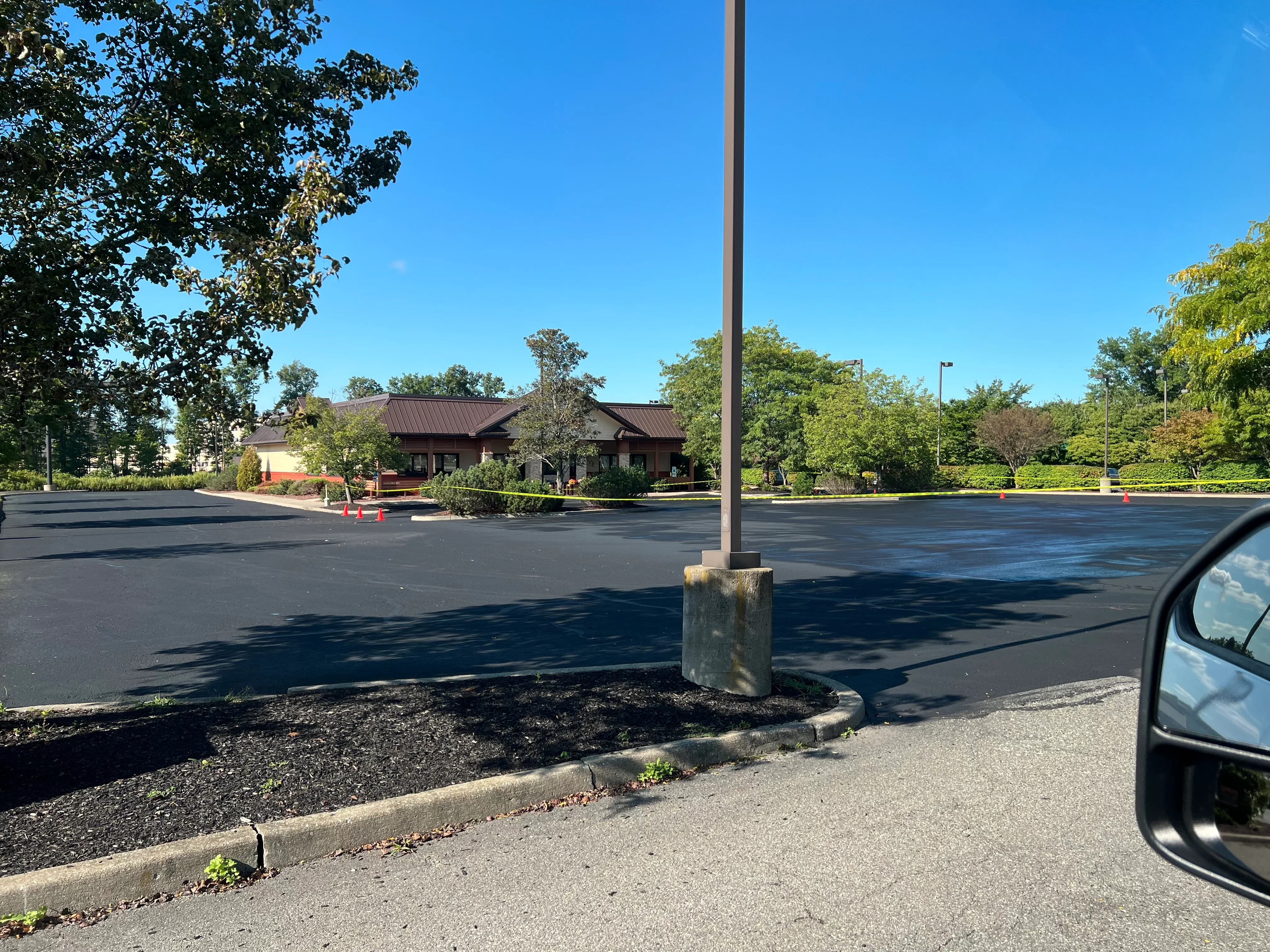 Newly paved commercial parking lot with fresh black asphalt and landscape edging